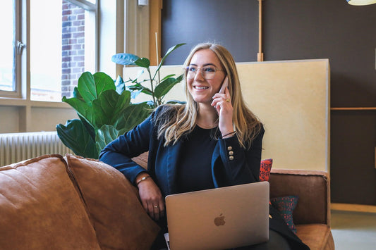 print on demand store owner using laptop sitting on sofa